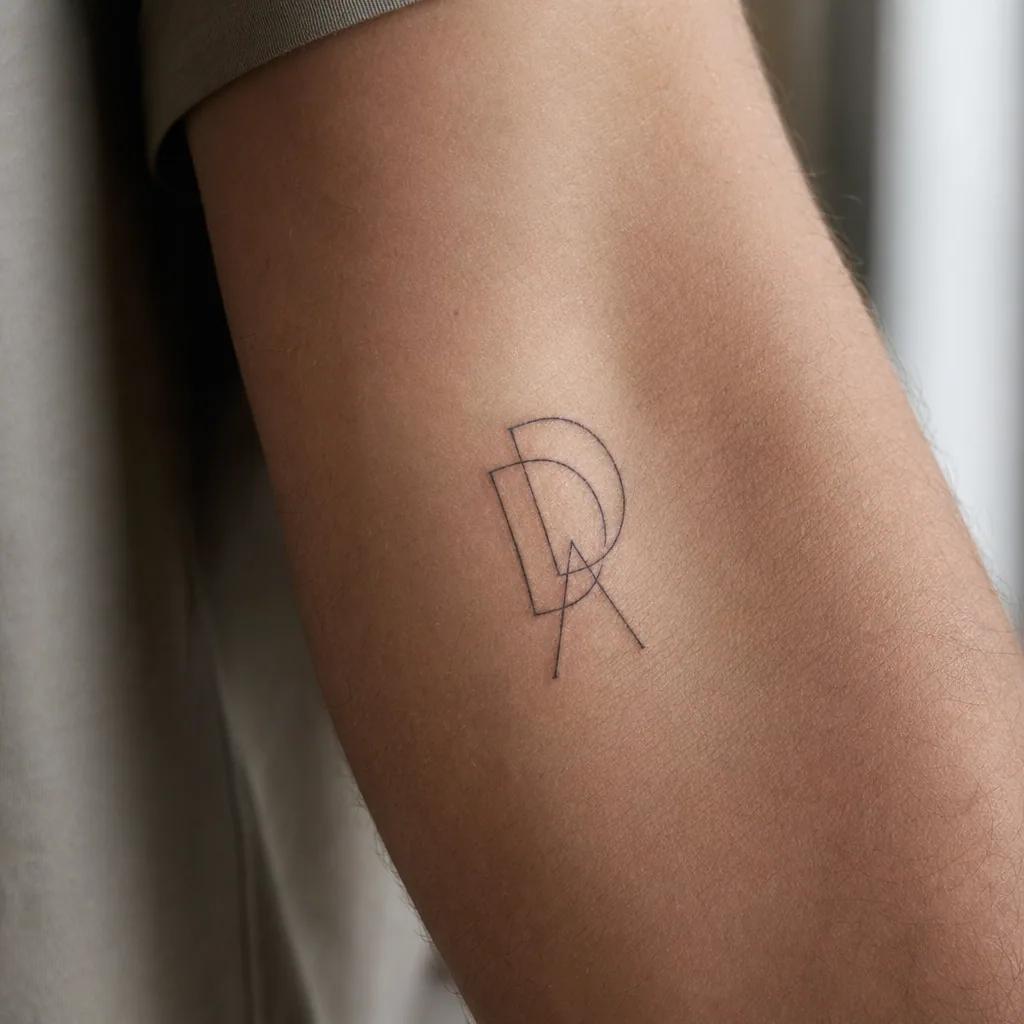 Initiales fine-line à l'avant-bras, design personnel à tester en temporaire