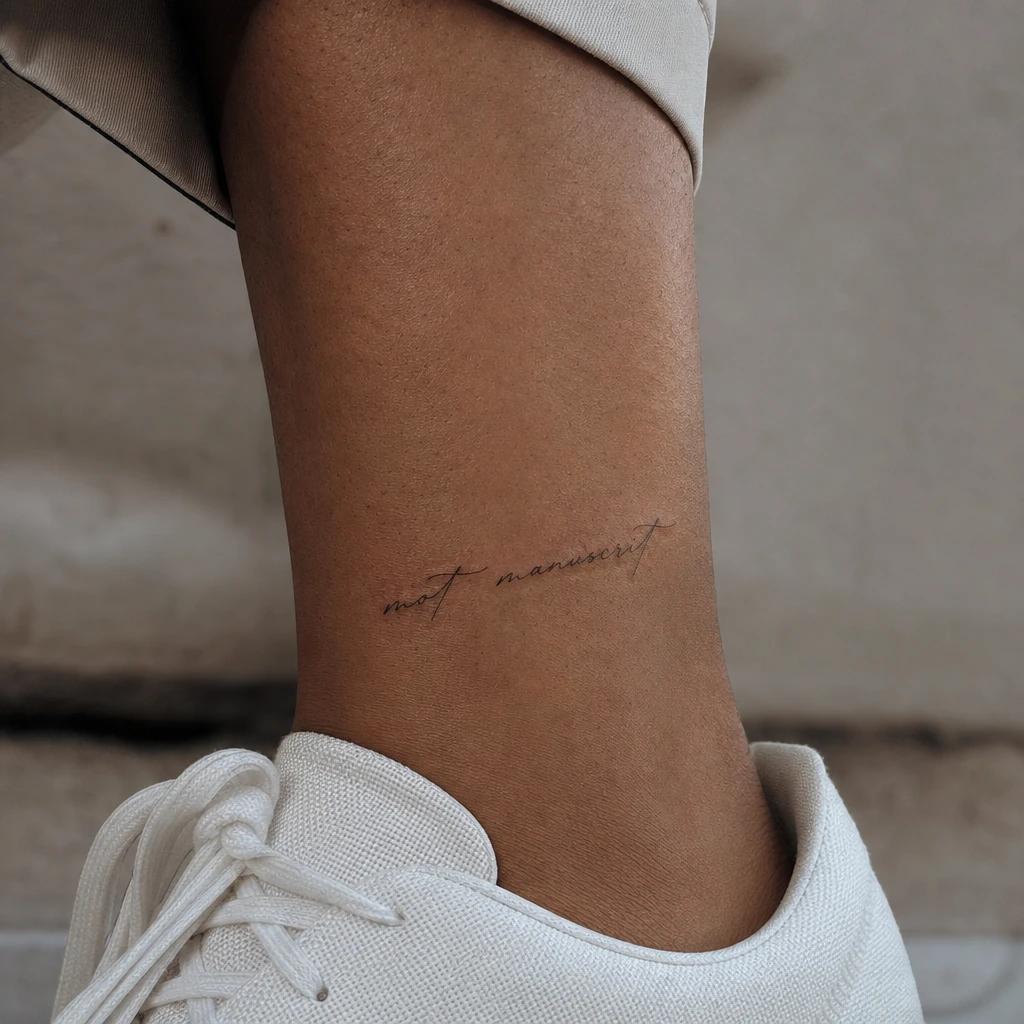 women's ankle tattoo handwritten word, realistic photo on skin